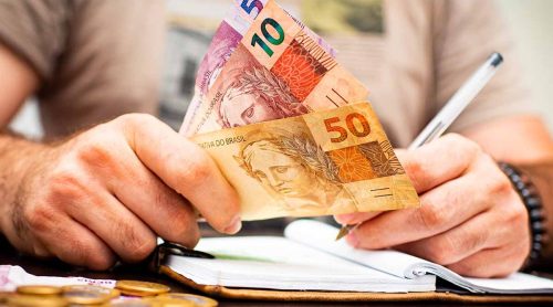 Trabalhador calculando o 13º salário e planejando o uso do benefício em 202